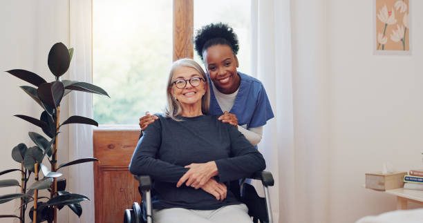 A nurse spending time with a senior client in her wheelchair at home